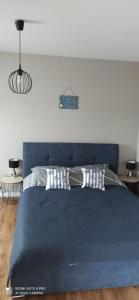Una cama azul con almohadas en el dormitorio en BelMare 424 en Międzyzdroje