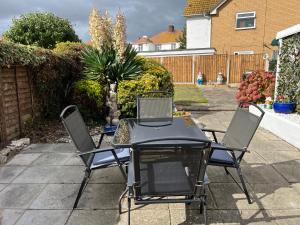 a table and chairs sitting on a patio at Seaside 2 bedroom house with large garden in Rhyl