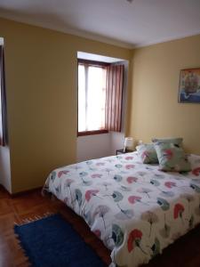 a bedroom with a bed with a comforter and a window at El Rincón de Sara in Tui
