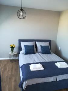 1 dormitorio con 1 cama con almohadas azules y blancas en BelMare 424 en Międzyzdroje