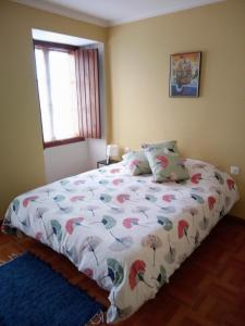 1 dormitorio con cama con edredón y ventana en El Rincón de Sara, en Tui