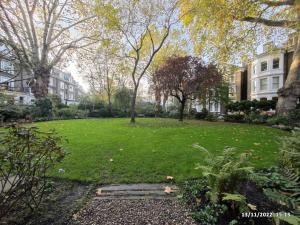 a park with trees and grass in a city at Luxury Apartment South Kensington in London