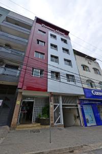 ein rot-weißes Gebäude in einer Stadtstraße in der Unterkunft Domus Hotel Veneza Ipatinga in Ipatinga