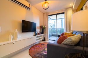Il comprend un salon doté d'un canapé et d'une télévision à écran plat. dans l'établissement Apartamento com Varanda e Vista Temporada MME, à Maceió
