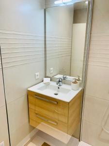 La salle de bains est pourvue d'un lavabo et d'un miroir. dans l'établissement Studio Confort 35m2 Rénové, Equipé et Climatisé, tout se fait à pied!, à Antibes