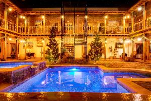 a swimming pool in front of a building at night at Hacienda Don Armando Boutique & Spa in Creel