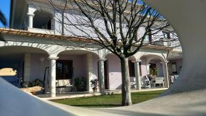 una casa blanca con un árbol en el patio en B&B Domus Aurea 20 en San Giovanni Teatino