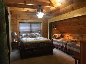 a bedroom with two beds in a log cabin at Glens of Antrim Mountain Cabin in Waynesville