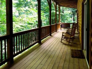 a porch of a cabin with a bench and a piano at Glens of Antrim Mountain Cabin in Waynesville
