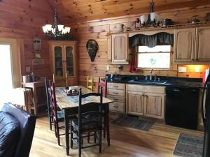 a kitchen with a table and a dining room at Glens of Antrim Mountain Cabin in Waynesville