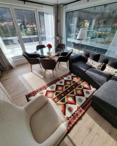 een woonkamer met een bank en een tafel en stoelen bij Apartamenty Nowa Osada - by VillaOlimpijska2 in Wisła