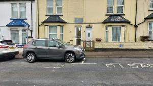 a car parked in a parking lot in front of houses at Rose Villa- Great For Long & Short Stays!!! in Gillingham