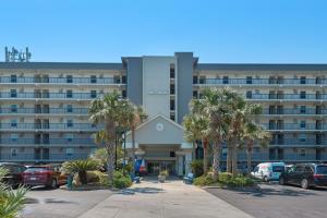 a large building with palm trees in a parking lot at Island Echos #2E in Fort Walton Beach