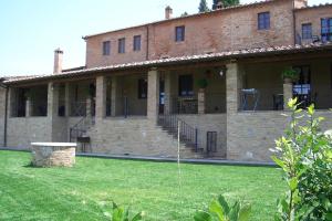 ein großes Backsteingebäude mit einem Rasenplatz davor in der Unterkunft Agriturismo S. Eurosia in Montalcino