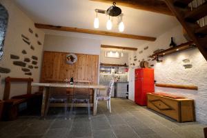 CASA DEL CECCO في Trontano: مطبخ مع طاولة وثلاجة حمراء