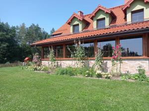 una casa con un jardín delante de ella en Dom pod Srebrnym Żurawiem, en Wydminy