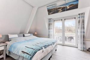 a bedroom with a bed and a large window at Vakantiehuis met Luxe Tuin dichtbij het strand in Kamperland