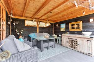 Una cocina y una sala de estar con un sofá y una mesa. en Vakantiehuis met Luxe Tuin dichtbij het strand, en Kamperland