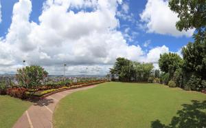 a park with a large lawn with flowers and trees at Hotel Aurora Towers in Pune