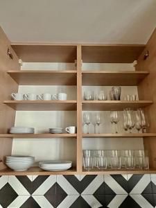 półka z talerzami, kieliszkami i naczyniami w obiekcie Smart Apartment Ogrodowa w Warszawie