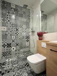 a bathroom with a black and white tile shower at Smart Apartment Ogrodowa in Warsaw