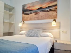 1 dormitorio con 1 cama con una pintura en la pared en Pension Yoldi, en San Sebastián