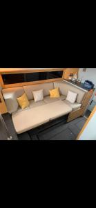 - un canapé blanc avec des oreillers jaunes sur un bateau dans l'établissement Giorgia House Boat, à Palerme