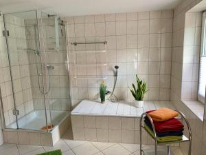a bathroom with a shower and a tub and a chair at Ferienwohnungen Marita in Salzwedel
