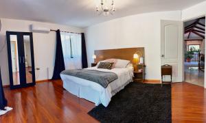 una camera con un grande letto e un pavimento in legno di South Landing Inn a Los Ángeles
