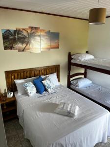 two beds in a room with two bunk beds at Luar de Araçatiba Suítes in Praia de Araçatiba