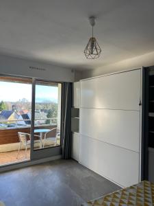 1 dormitorio con una gran puerta corredera con vistas a un patio en Studio tout confort, en Bagnoles de l'Orne