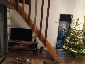 a living room with a christmas tree and a staircase at Wooden cave in Diessen