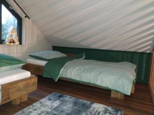 DiessenにあるWooden caveの緑と白のベッドが備わる客室です。