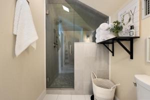 La salle de bains est pourvue d'une douche avec une porte en verre. dans l'établissement The Plantation House Boutique Inn, à Pflugerville