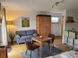 a living room with a blue couch and a table at Mosel-Auszeit in Brauneberg