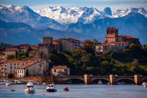 a city with boats in the water and mountains at El Mirador de San Vicente in San Vicente de la Barquera
