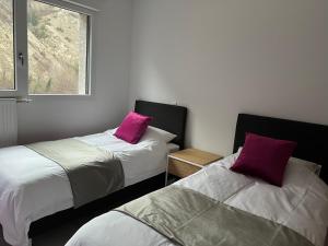two beds with purple pillows in a room at La Niche 2 in Brides-les-Bains