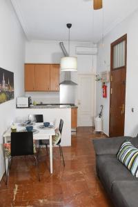 cocina y sala de estar con mesa y sofá en Apartamento Descalzos, en Sevilla