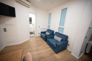 a living room with two blue chairs and a television at Angelico Luxury House in Rome