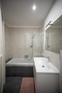 a white bathroom with a tub and a sink at Angelico Luxury House in Rome