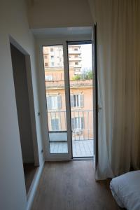 una camera da letto con porta che si apre su un balcone di Angelico Luxury House a Roma