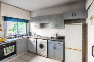 a kitchen with gray cabinets and a washer and dryer at private room in a shared flat at best location in Limassol