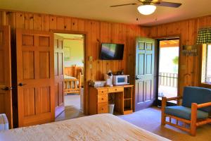 a bedroom with a bed and a desk with a microwave at Twin Peaks Guest Ranch in Salmon