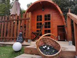 eine kleine Holzhütte mit einem Korb auf einem Deck in der Unterkunft Ma cabane au fond du jardin in Porto-Vecchio