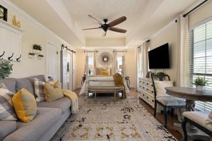 a living room with a couch and a ceiling fan at The Plantation House Boutique Inn in Pflugerville
