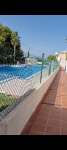 une clôture à maillons à côté d'une piscine dans l'établissement Apartamento bajo con terraza y piscina, à Torrevieja
