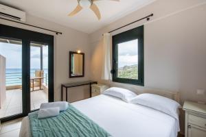 a bedroom with a bed with a view of the ocean at Portela Apartments Kastri in Keratokampos