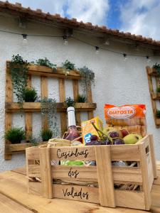a wooden crate filled with fruit and a bottle of wine at Casinhas dos Valados in Atouguia da Baleia