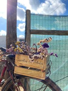 een fiets met een mand vol bloemen erop bij Casinhas dos Valados in Atouguia da Baleia