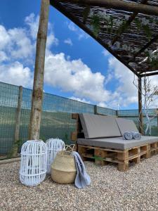 una cama y cestas sentadas bajo un pabellón en Casinhas dos Valados, en Atouguia da Baleia